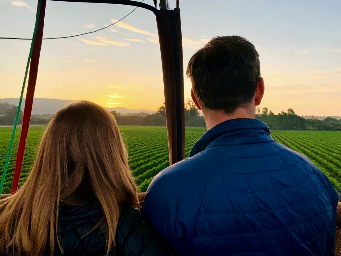 Couple watching the sunrise from a private balloon basket
