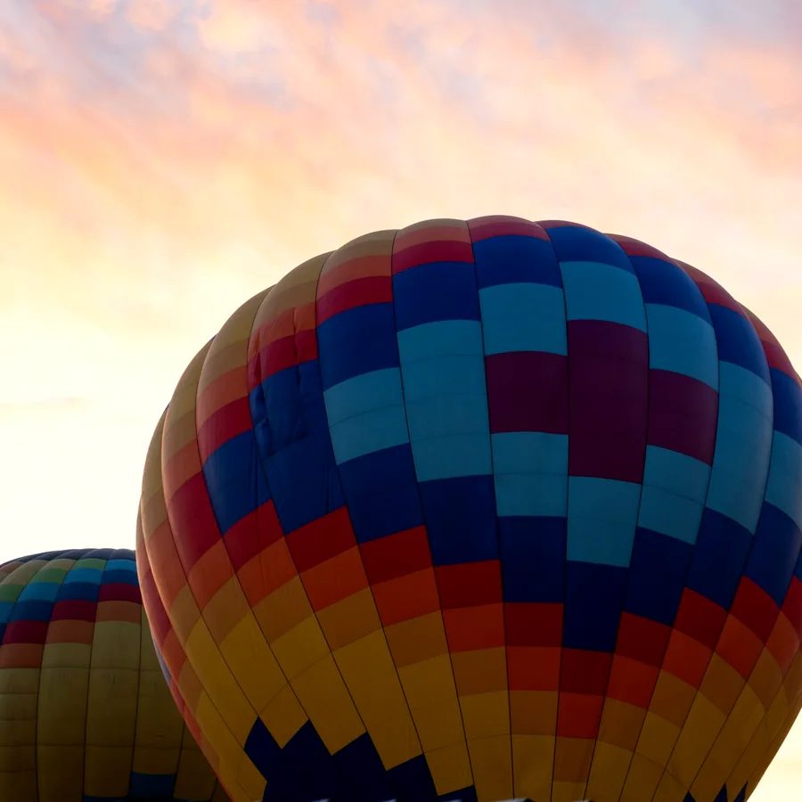 Colorful balloons against sunrise clouds